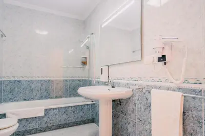 a white bathroom with a sink and a mirror at PENSIÓN AUGAS QUENTES in Caldas de Reis