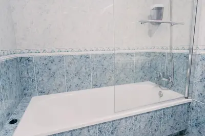 a bathroom with a white tub and blue tiles at PENSIÓN AUGAS QUENTES in Caldas de Reis