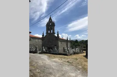 an old church with a tower on a cemetery at CASA ALBA DE SAN ROMÁN in Ourense