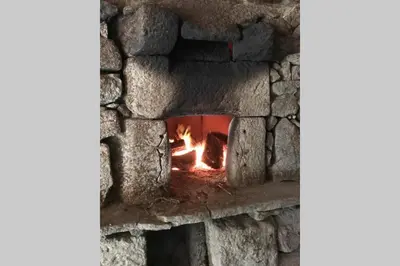 a brick oven with a fire in it at CASA ALBA DE SAN ROMÁN in Ourense