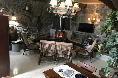 a living room with chairs and a table and a tv at CASA ALBA DE SAN ROMÁN in Ourense