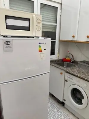 a kitchen with a microwave on top of a refrigerator at Atico en el casco histórico in Santiago de Compostela