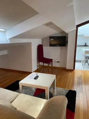 a living room with a couch and a table at Atico en el casco histórico in Santiago de Compostela