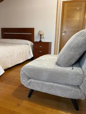 a bedroom with a chair in front of a bed at VUT Boente in Boente