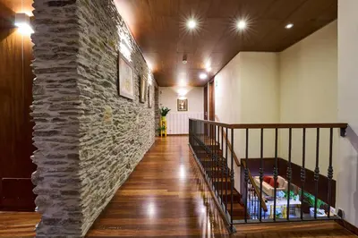 a staircase in a building with a stone wall at Lar da Mota Boutique Hotel in Arzúa