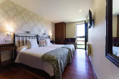 a bedroom with two beds and a mirror at Lar da Mota Boutique Hotel in Arzúa