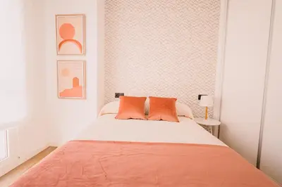 a bedroom with a large bed with orange pillows at Apartamentos Rúa Vella in Caldas de Reis