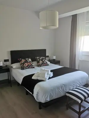 a bedroom with a large bed with a black headboard at Seijo in Villalba
