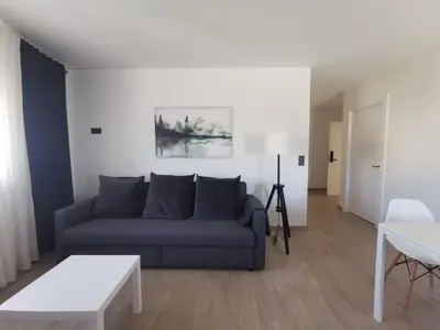 a living room with a blue couch and a table at Seijo in Villalba