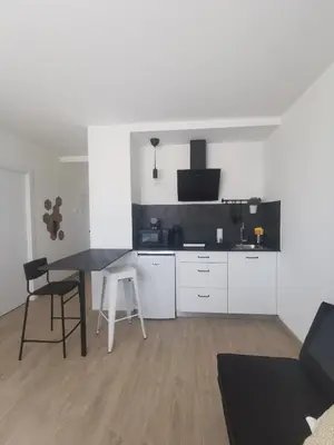 a kitchen with white cabinets and a table and chairs at Seijo in Villalba