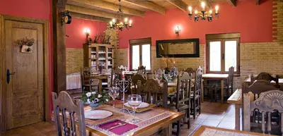 a dining room with a table and chairs and red walls at CASA ALTOBIERZO, 9 Habitaciones y 9 BAÑOS in Pobladura de las Regueras