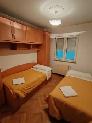 a room with two beds and a window at Apartamentos Quien Anda Ahí Ribadeo in Ribadeo