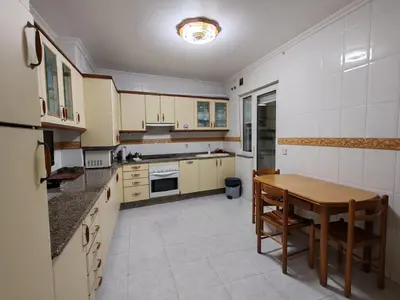 a large kitchen with a wooden table and a tableablish at Apartamentos Quien Anda Ahí Ribadeo in Ribadeo