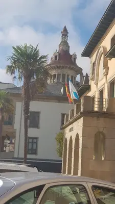 a car parked in front of a building with two flags at Apartamentos Quien Anda Ahí Ribadeo in Ribadeo