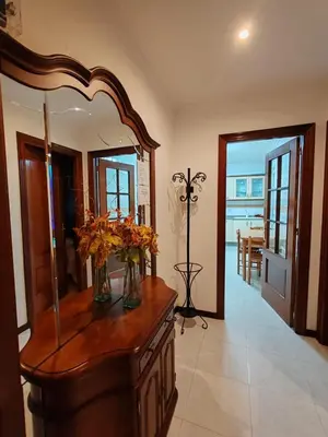 a room with a mirror and a dresser with flowers on it at Apartamentos Quien Anda Ahí Ribadeo in Ribadeo