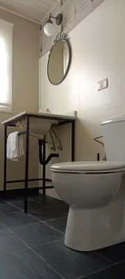 a bathroom with a sink and a toilet and a mirror at Casa de Arriba in Rinlo