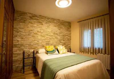 a bedroom with a bed and a brick wall at Casa dos arcos in Sober