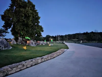 a driveway with a stone wall next to a park at Casa dos arcos in Sober