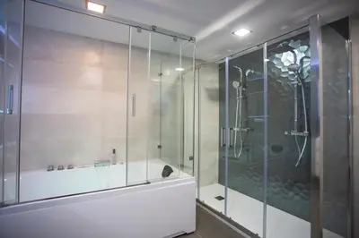 a glass shower in a bathroom with a tub at Casa dos arcos in Sober