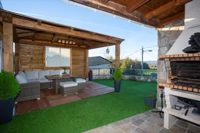 an outdoor patio with a fireplace and green grass at Casa dos arcos in Sober