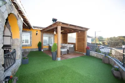 an outdoor patio with a pergola and grass at Casa dos arcos in Sober