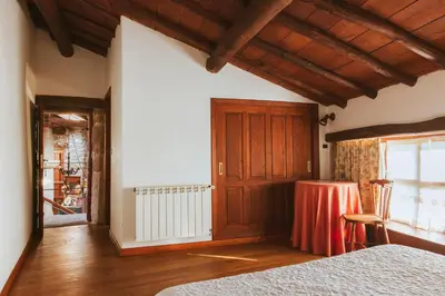 a bedroom with a bed and a table and a window at Casa Do Romualdo in Vilela