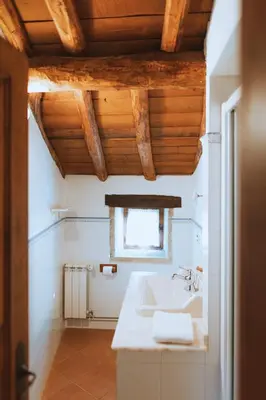 a white bathroom with a sink and a window at Casa Do Romualdo in Vilela