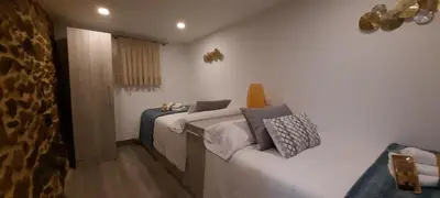 a bedroom with two beds and a couch at Apartamentos Casa dos Arcos in Sober