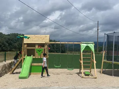 a young boy is playing on a playground at Apartamentos Casa dos Arcos in Sober