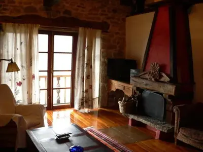 a living room with a fireplace and a television at El Taller De La Seda in Avedillo de Sanabria