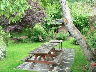 a wooden picnic table sitting next to a tree at El Taller De La Seda in Avedillo de Sanabria