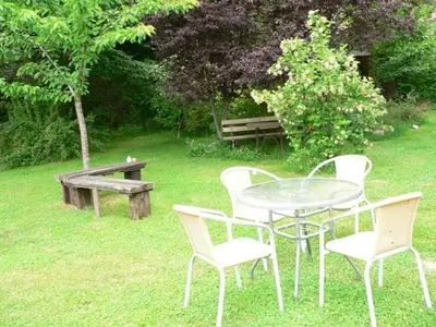 a table and chairs and a bench in a yard at El Taller De La Seda in Avedillo de Sanabria