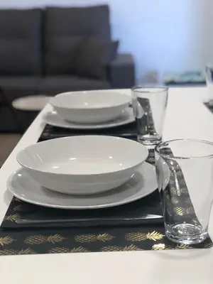 a table with plates and glasses on a table at Huellas Albergue-Turístico in Portomarin