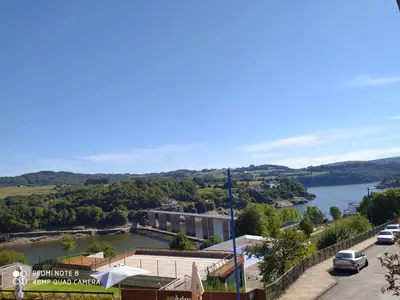 a view of a river and a town with a lake at Huellas Albergue-Turístico in Portomarin