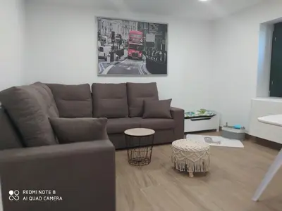 a living room with a couch and a red double decker bus at Huellas Albergue-Turístico in Portomarin