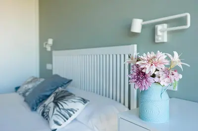 a blue vase with flowers on top of a bed at Carrioza Alojamiento Turístico in Parada del Sil