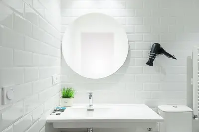 a white bathroom with a sink and a mirror at Carrioza Alojamiento Turístico in Parada del Sil