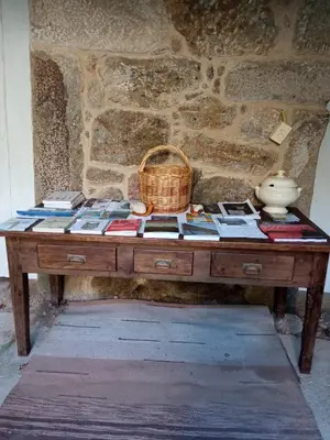 a wooden table with books and a basket on it at Casa MiraXurés con vistas a la Sierra del Xurés in Ourense