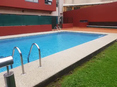 a swimming pool with blue water in a building at Piso con piscina en Sada in Sada