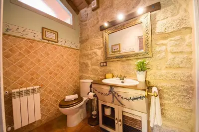 a bathroom with a sink and a toilet and a mirror at Cas do Mestre - Casa rural con Encanto in Pontevedra