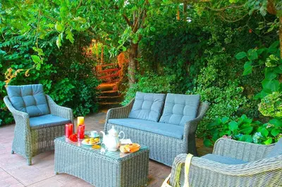 a patio with three chairs and a table with candles at Cas do Mestre - Casa rural con Encanto in Pontevedra
