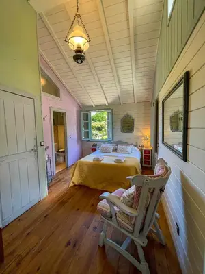 a bedroom with a bed and a chair in a room at Cas do Mestre - Casa rural con Encanto in Pontevedra