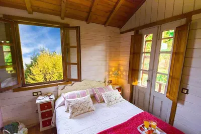 a bedroom with a bed in a room with windows at Cas do Mestre - Casa rural con Encanto in Pontevedra