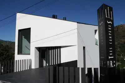 a house with a black and white facade at Hostal Tres Campanas in Villafranca del Bierzo