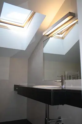 a bathroom with a sink and a skylight at Hostal Tres Campanas in Villafranca del Bierzo