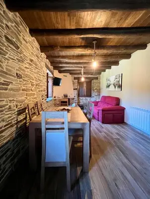 a dining room with a table and a pink couch at Casa A Poza in Samos