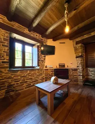 a living room with a table and a brick wall at Casa A Poza in Samos