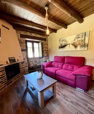 a living room with a purple couch and a table at Casa A Poza in Samos
