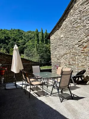 a patio with a table and chairs and an umbrella at Casa A Poza in Samos