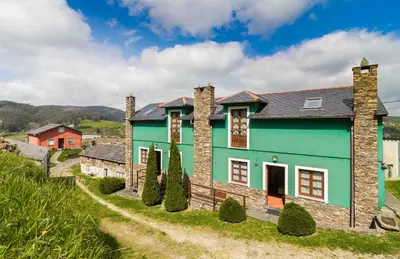 a blue and green house with trees in front of it at apartamentos castrovaselle nº2 in Castrovaselle